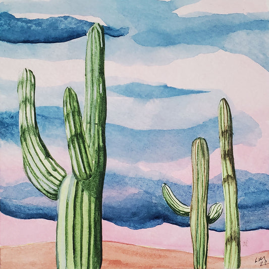 Original watercolor painting of saguaro cacti with pink and blue monsoon skies in the background Painting is mounted on wood panel with hanging wire on the back 5 inches x 5 inches x 3/4 inch Signed  2022